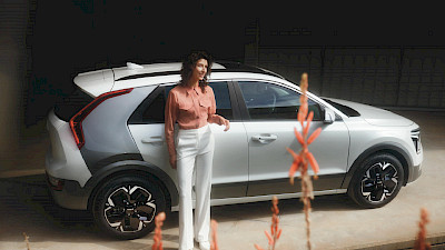 Nő áll a Kia Niro mellett