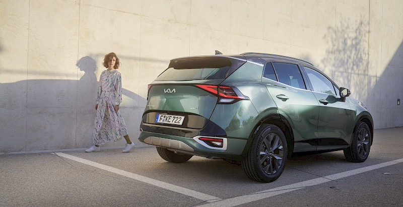Nő elsétál a Kia Sportage mellett