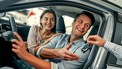 Férfi és nő átveszi új autójuk kulcsát