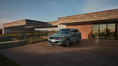 Új Kia Sorento modell parkol a modern ház előtt