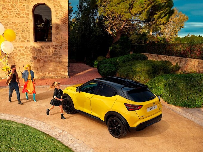 Család lufival a kezében sétál a Nissan Juke felé