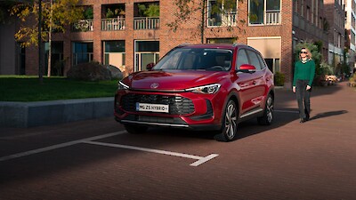 MG ZS Hybrid + modellhez sétál oda a nő