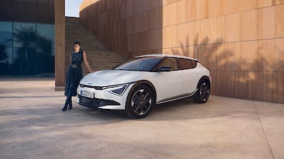 Nő támaszkodik a Kia EV6 mellett