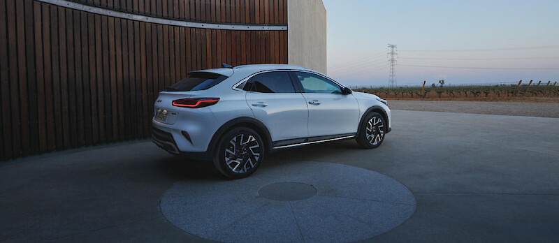 Kia XCeed áll a lambériás épület mellett