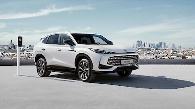 MG HS PHEV modell áll az MG töltő mellet