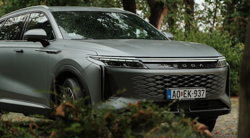 Omoda 9 SHS áll a bokor mögött