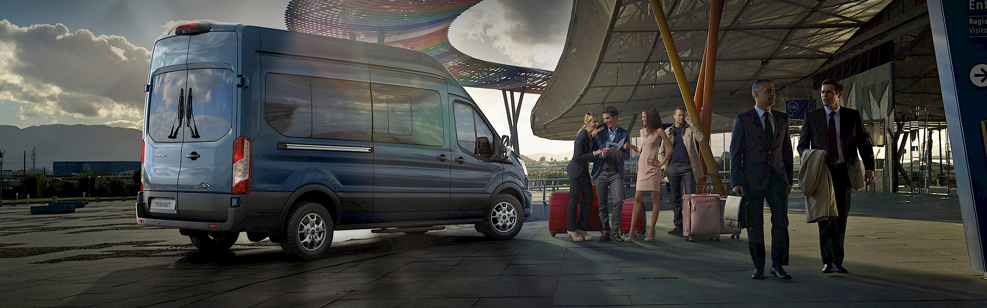 Utasok várakoznak egy Ford Transit Minibusz mellett a repülőtéren